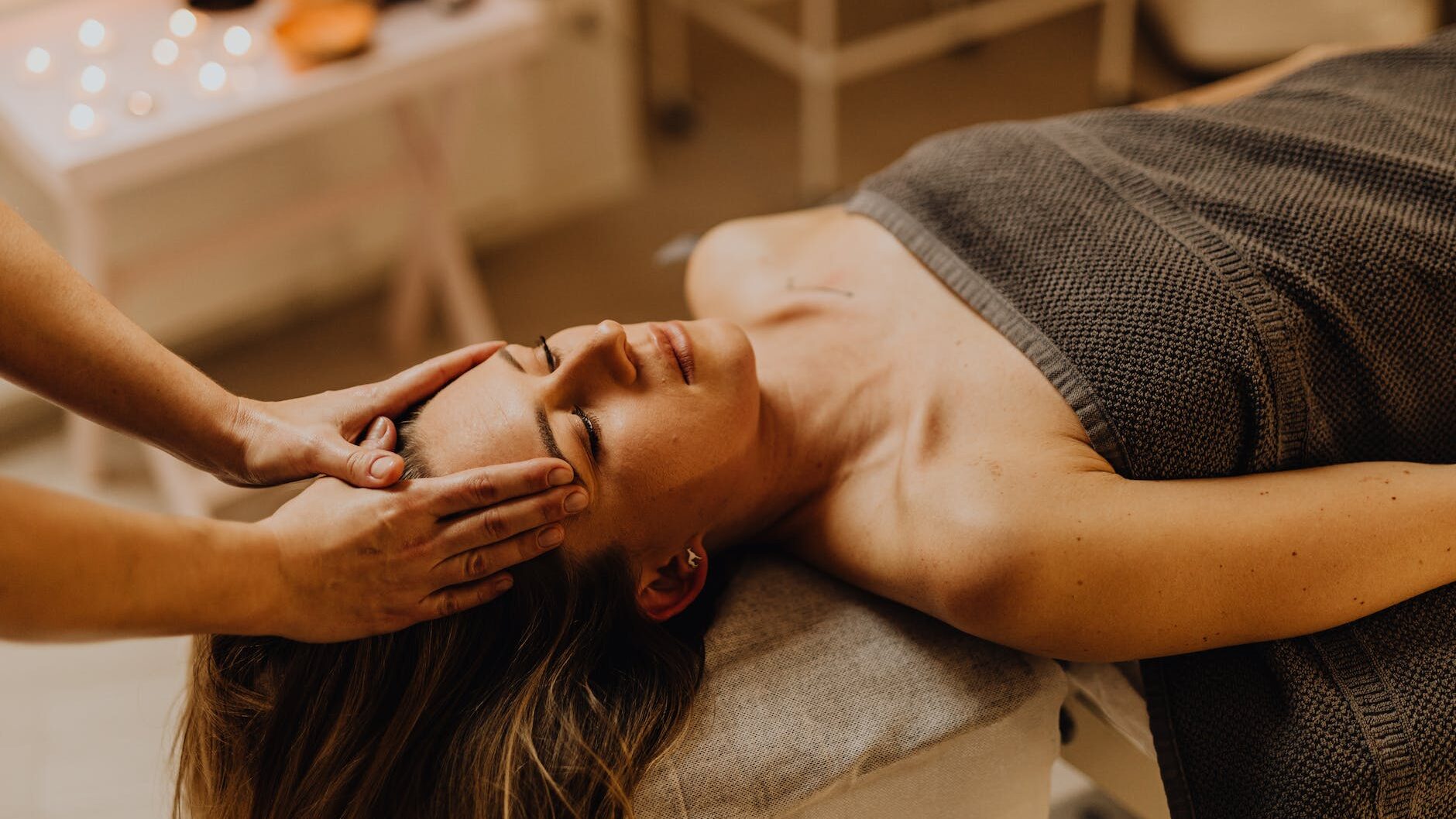 hands of a person massaging a woman s head