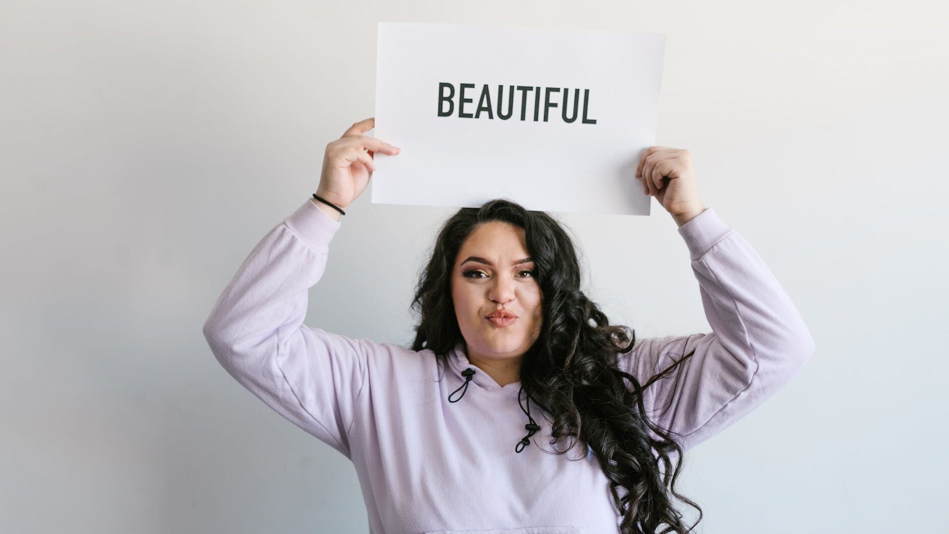 woman wearing a sweater holding a placard